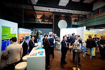 Conference participants networking around the exhibition